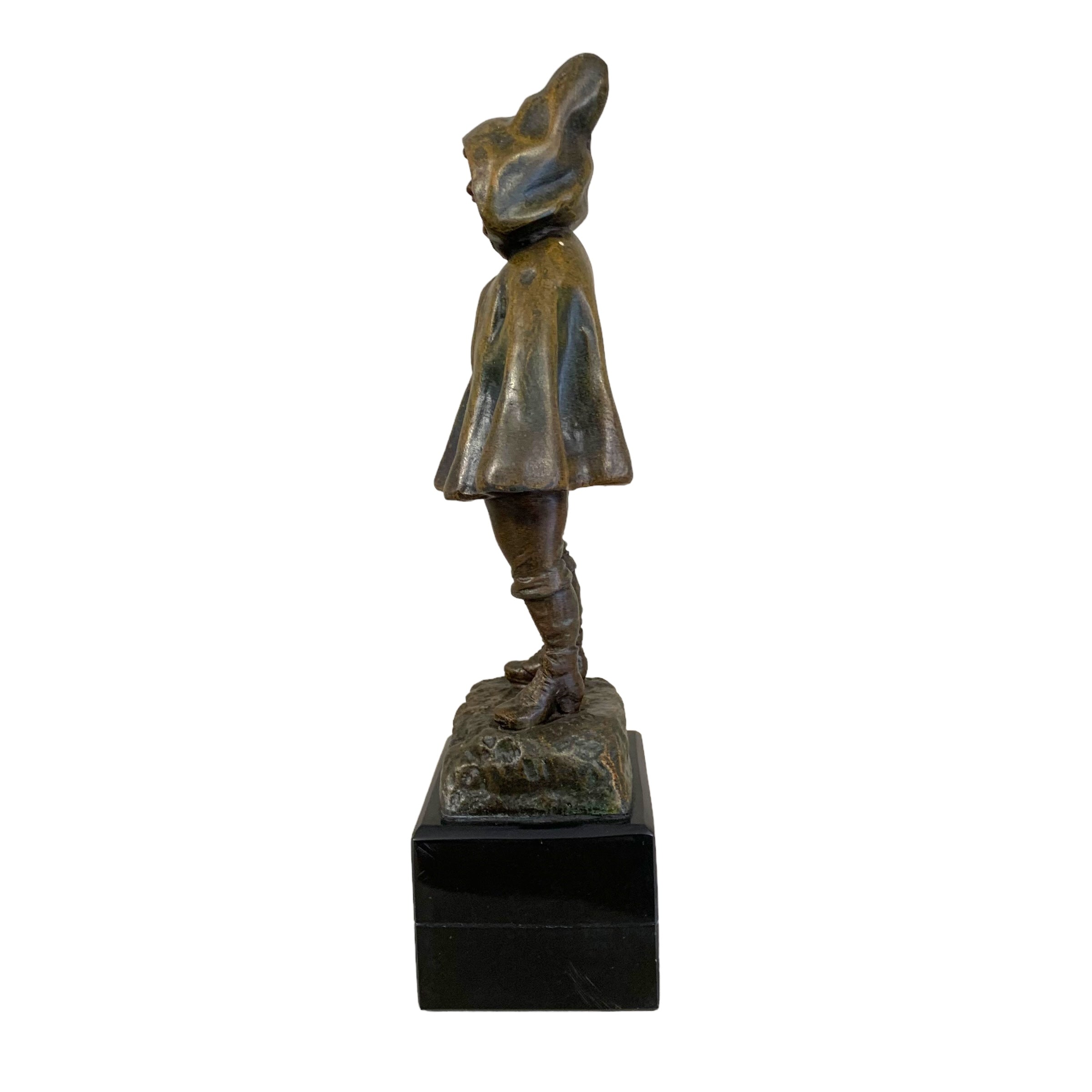 Escultura peltre de niña con capa. SXX