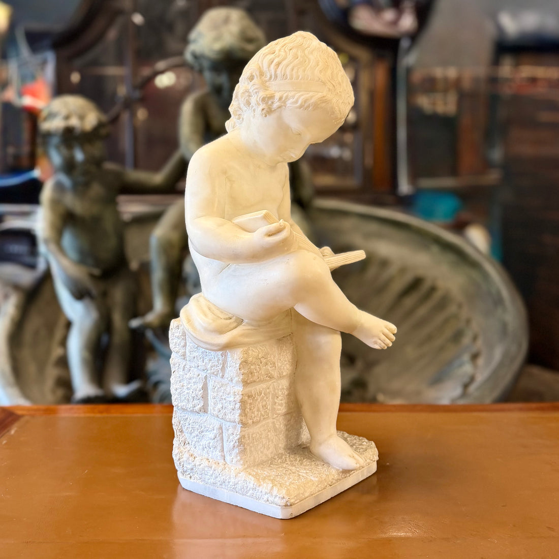 Escultura de alabastro de un "putti" niño leyendo tranquilamente. Italia SXIX