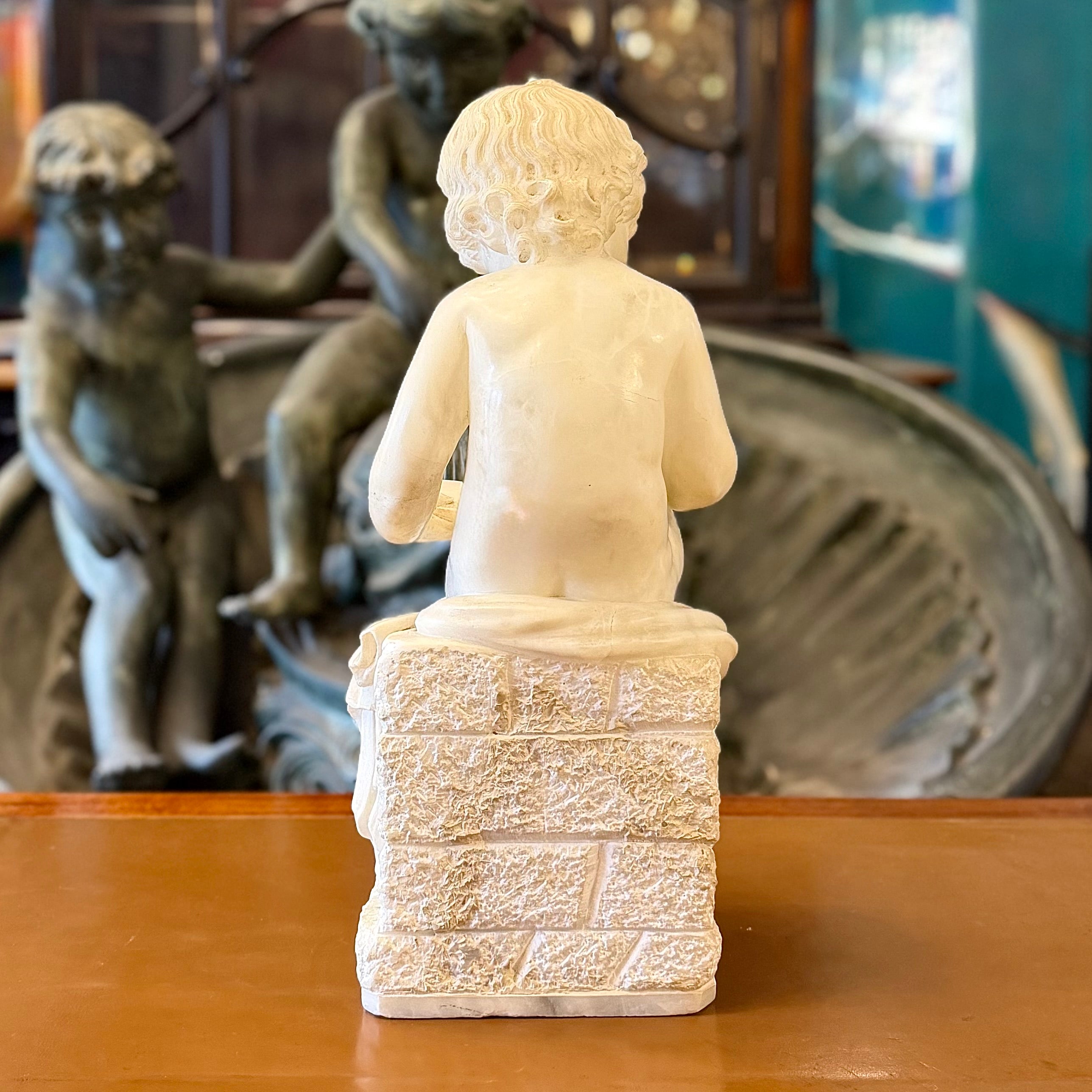Escultura de alabastro de un "putti" niño leyendo tranquilamente. Italia SXIX