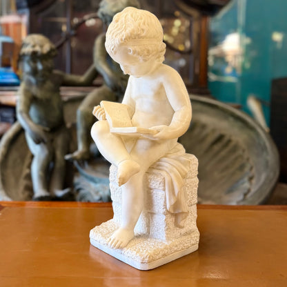 Escultura de alabastro de un "putti" niño leyendo tranquilamente. Italia SXIX